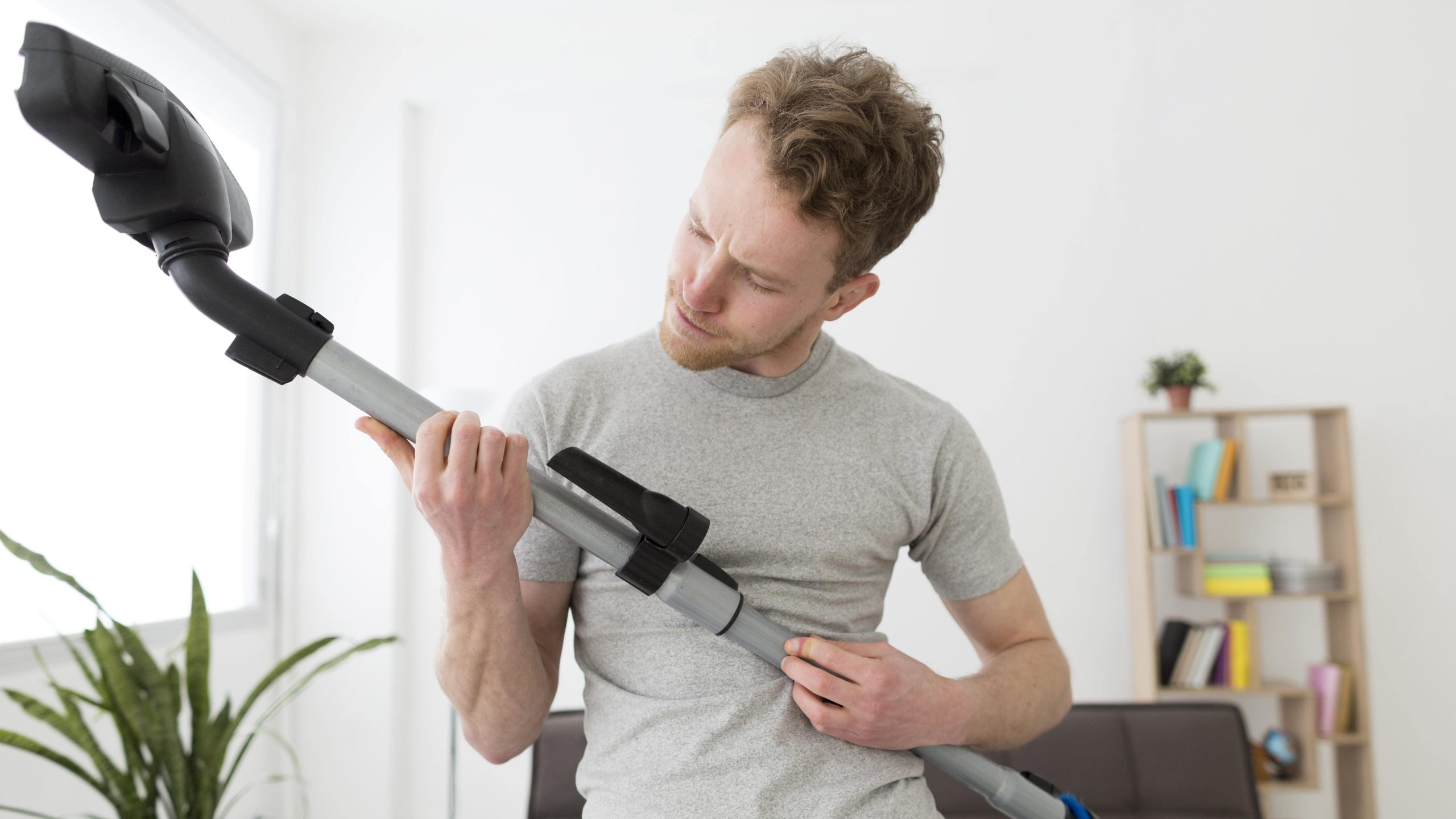 Man cleaning house with vacuum - central vacuum repair Sunrise FL