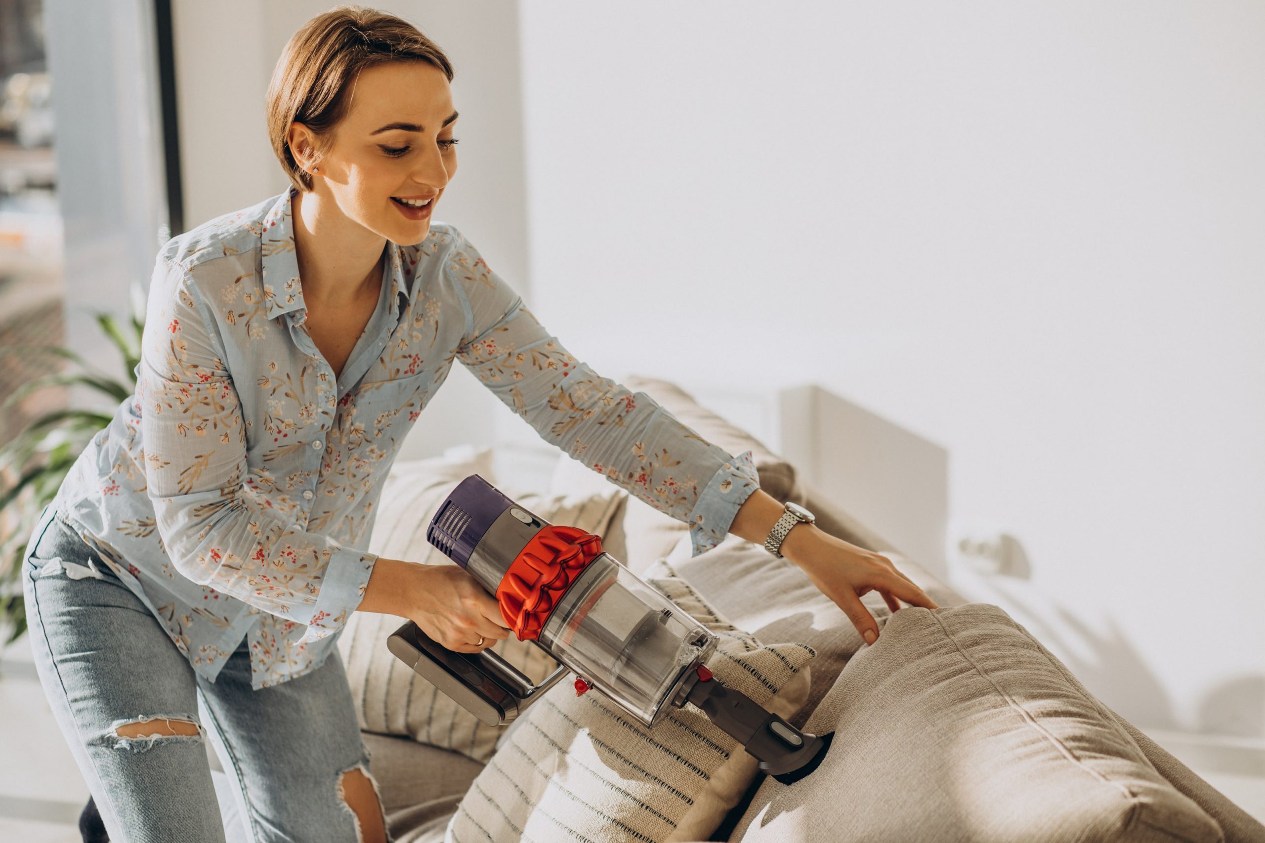 Young woman cleaning home with rechargeable vacuum cleaner - Hollywood central vacuum repair