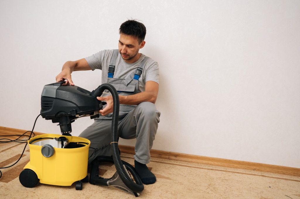 Professional vacuum technician inspecting a central vacuum unit