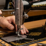 Sewing machine on a work table with fabric and repair tools